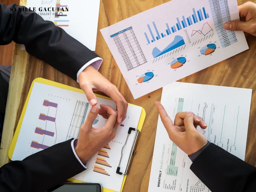 Business discussion with printed analytics reports on a table.
