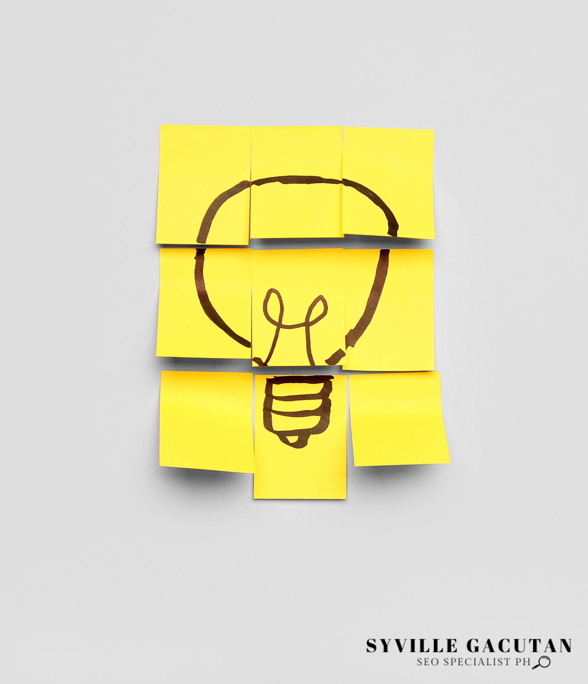 A lightbulb drawn on yellow sticky notes arranged in a puzzle-like pattern on a gray background.