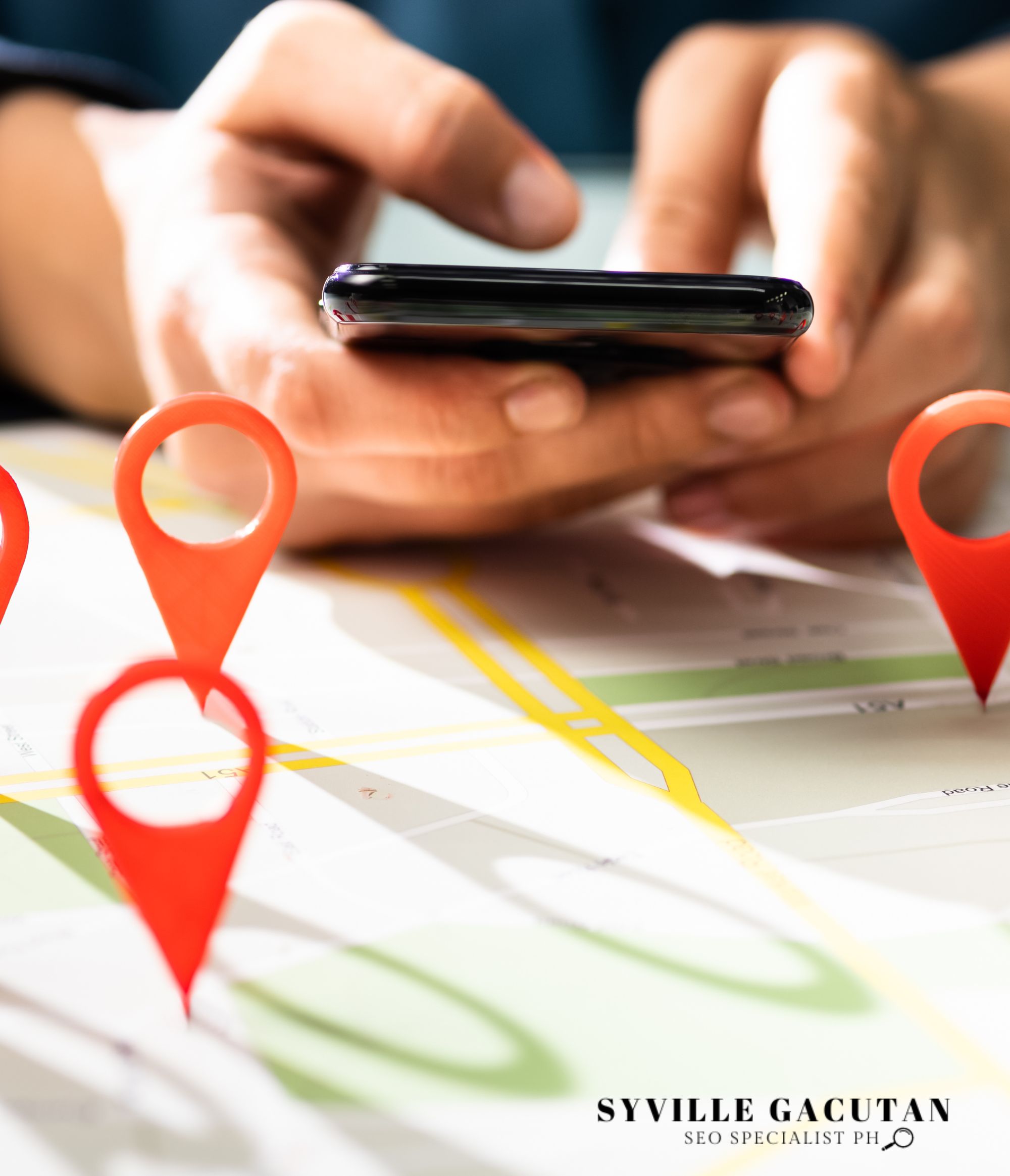 Hands using a phone over a map with location pins.