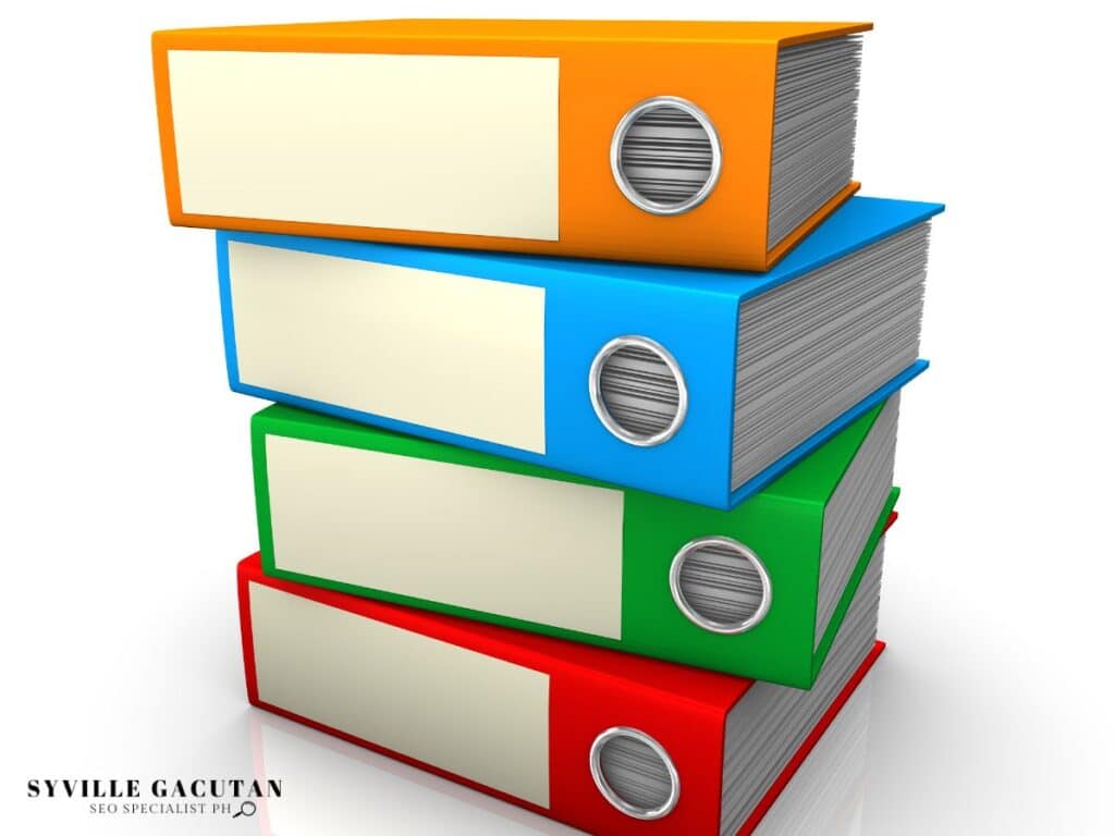Stack of colorful office binders with blank labels and circular handles, organized neatly.