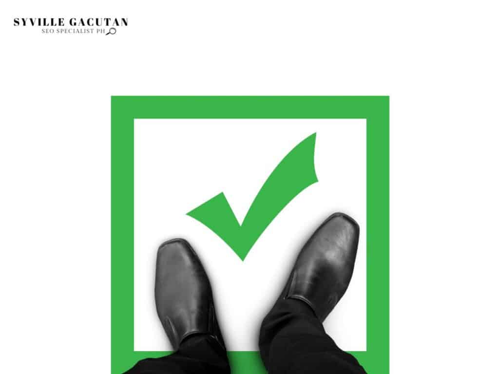 Black shoes on white background with green checkmark in a green frame.