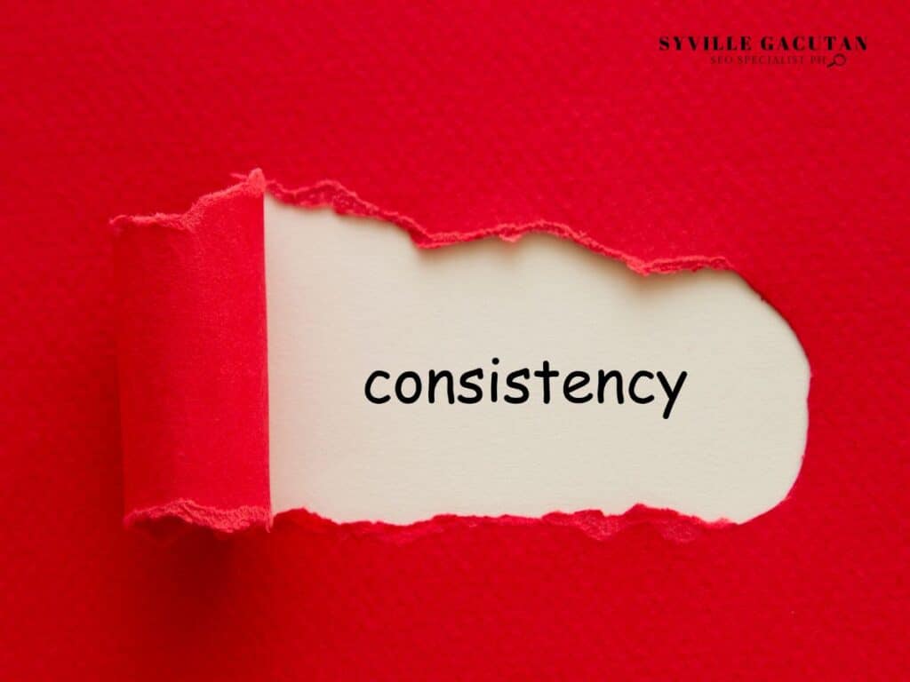 Red torn paper revealing the word "consistency" on white background.
