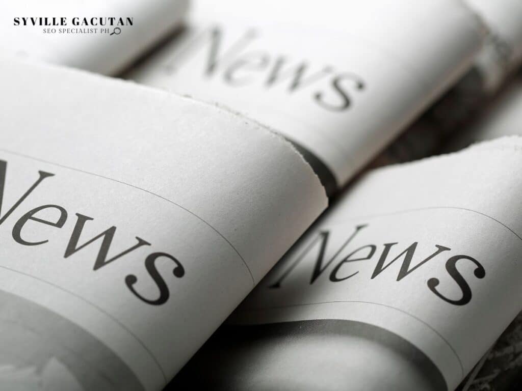 Close-up of folded newspapers with the word "News" printed in bold.