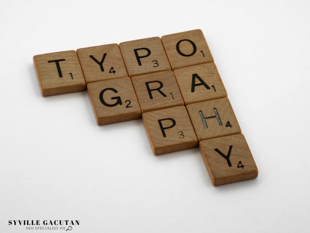 Wooden Scrabble-like tiles arranged to spell "TYPOGRAPHY" in a crossword pattern.

