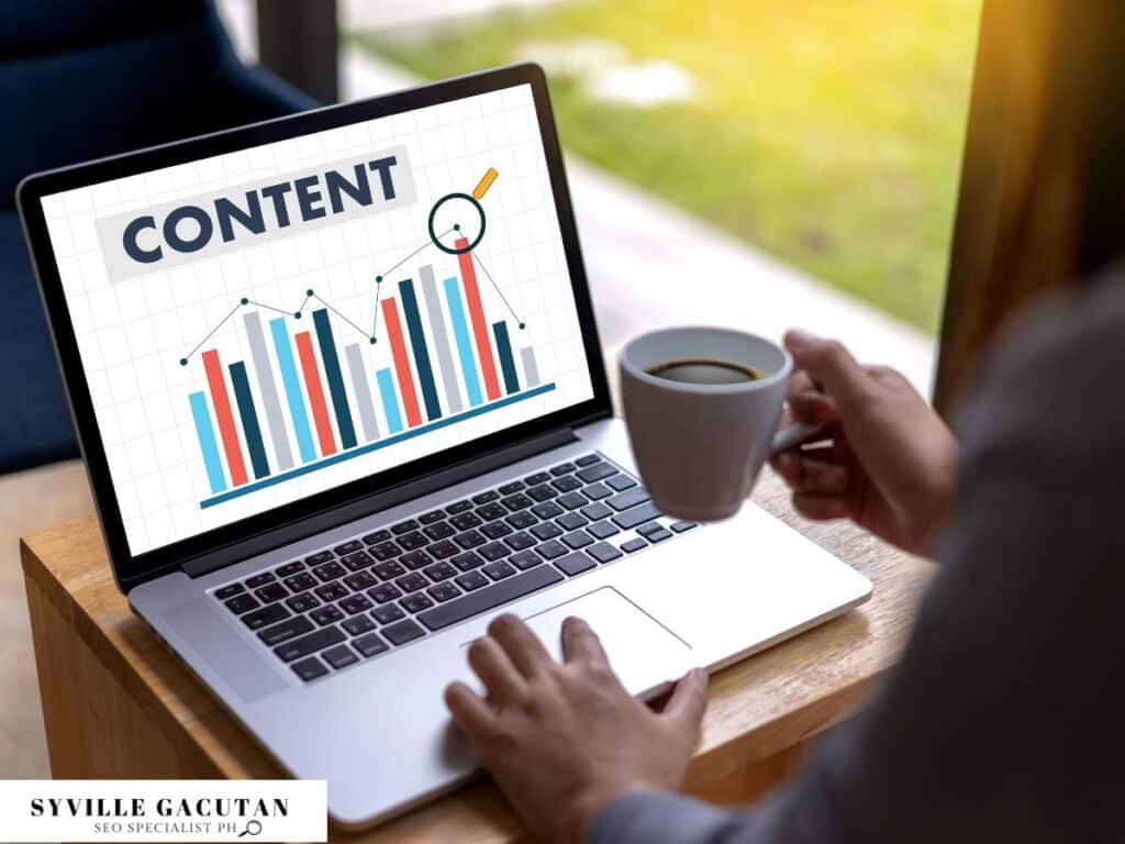 A laptop screen showing a content graph while holding a coffee cup.