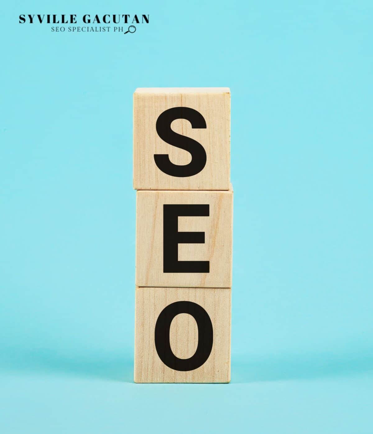 Wooden blocks spelling "SEO" on a turquoise background.