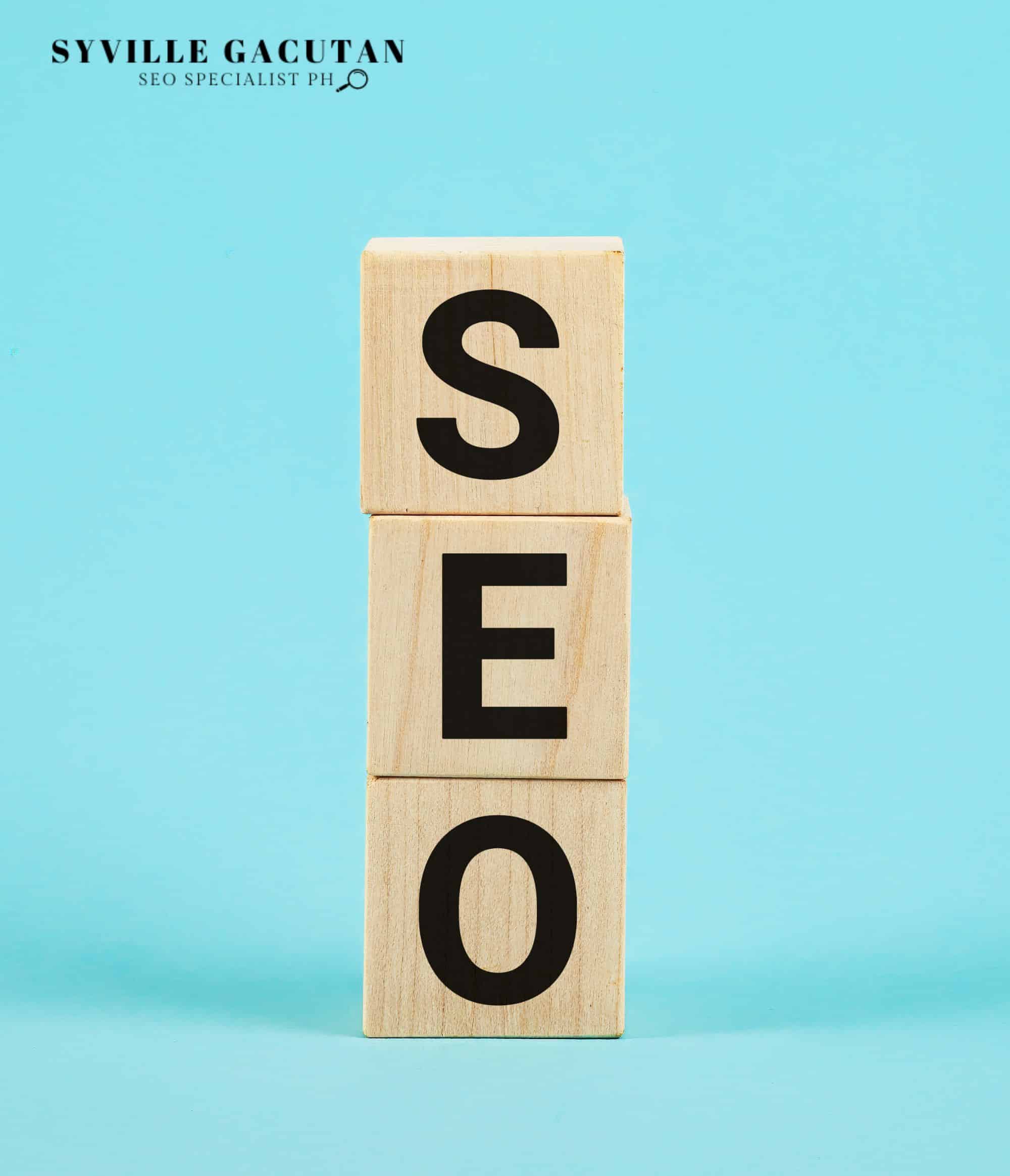 Wooden blocks spelling "SEO" on a turquoise background.