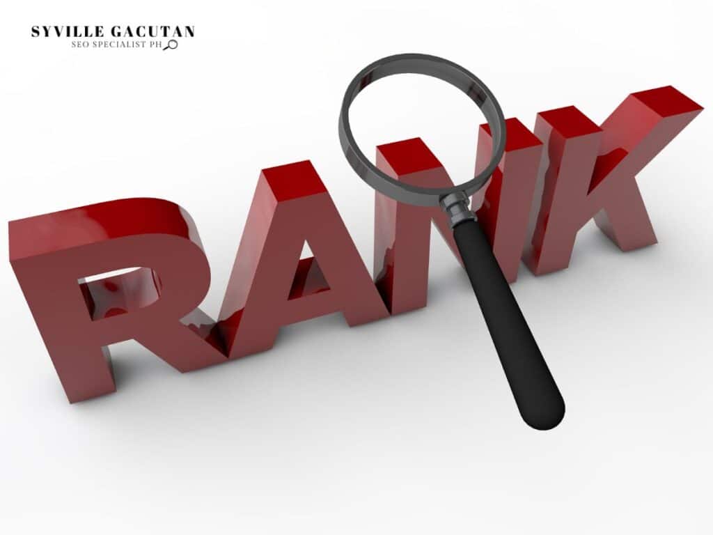 Red 3D text "RANK" with magnifying glass examining letters on white background.