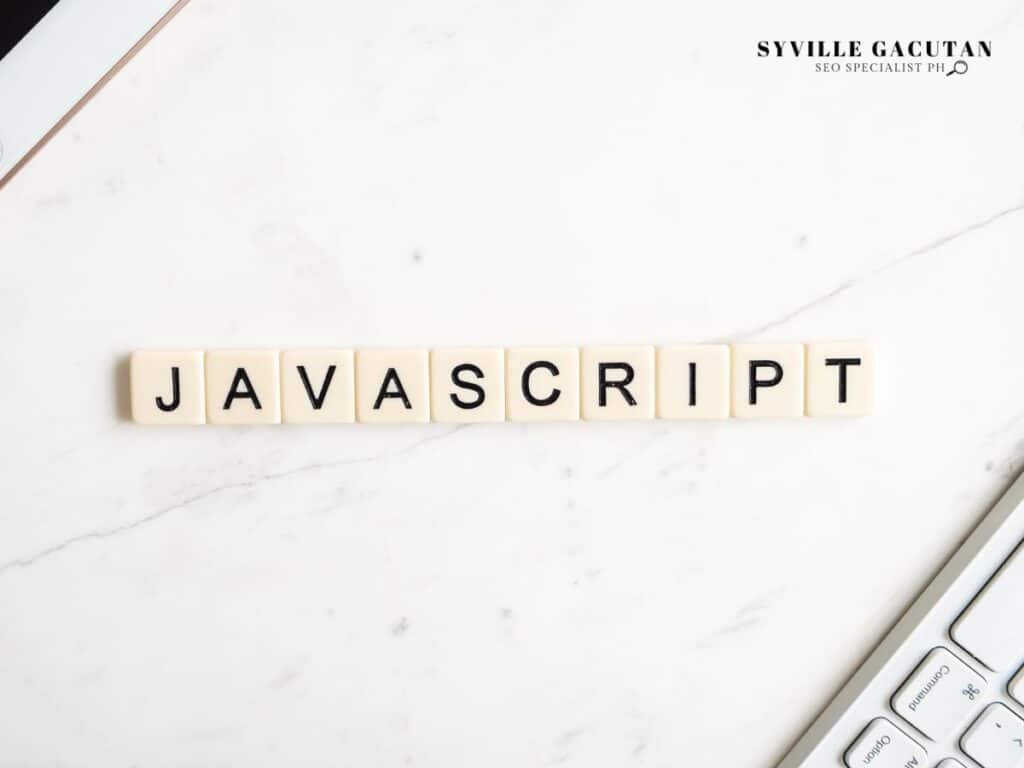 JavaScript spelled with letter tiles on a marble surface.