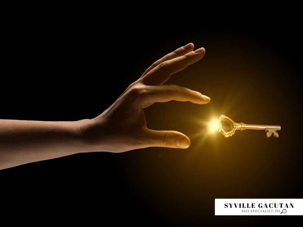 Hand reaching for glowing golden key against dark background.