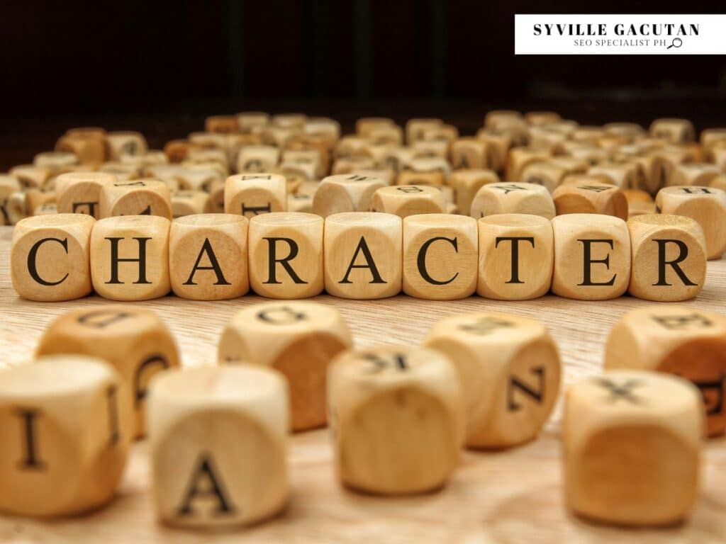 Wooden letter blocks spelling "CHARACTER" with scattered alphabet dice in warm lighting.