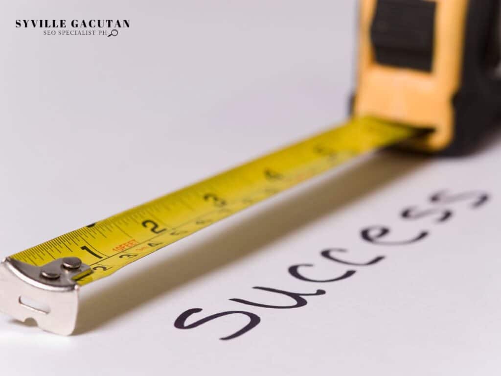 Yellow measuring tape next to handwritten "SUCCESS" text on white surface.