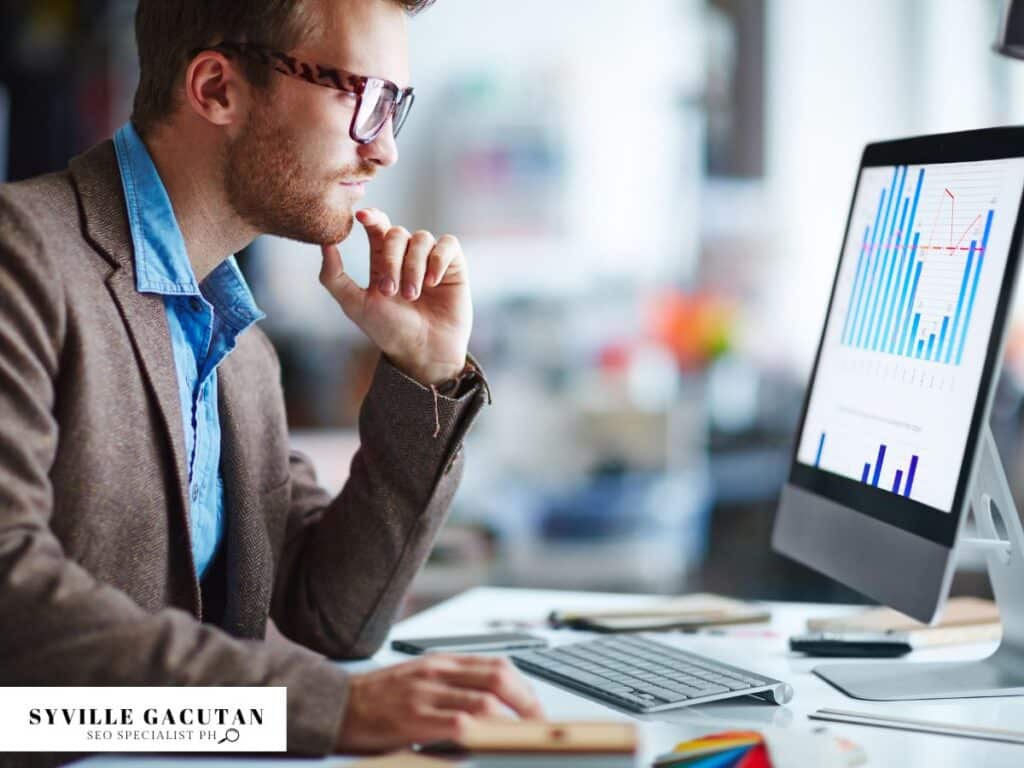 Man analyzing colorful graphs and charts on computer screen, focused on data interpretation.