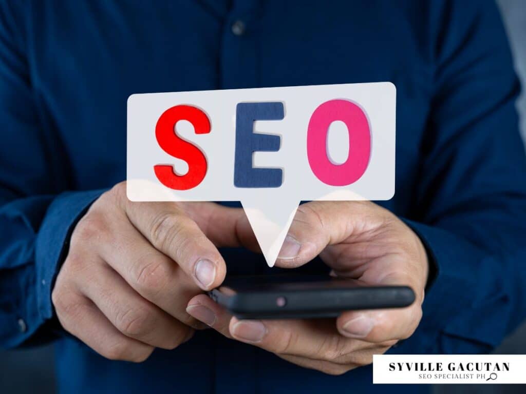 The word "SEO" in a speech bubble above a person holding a smartphone.