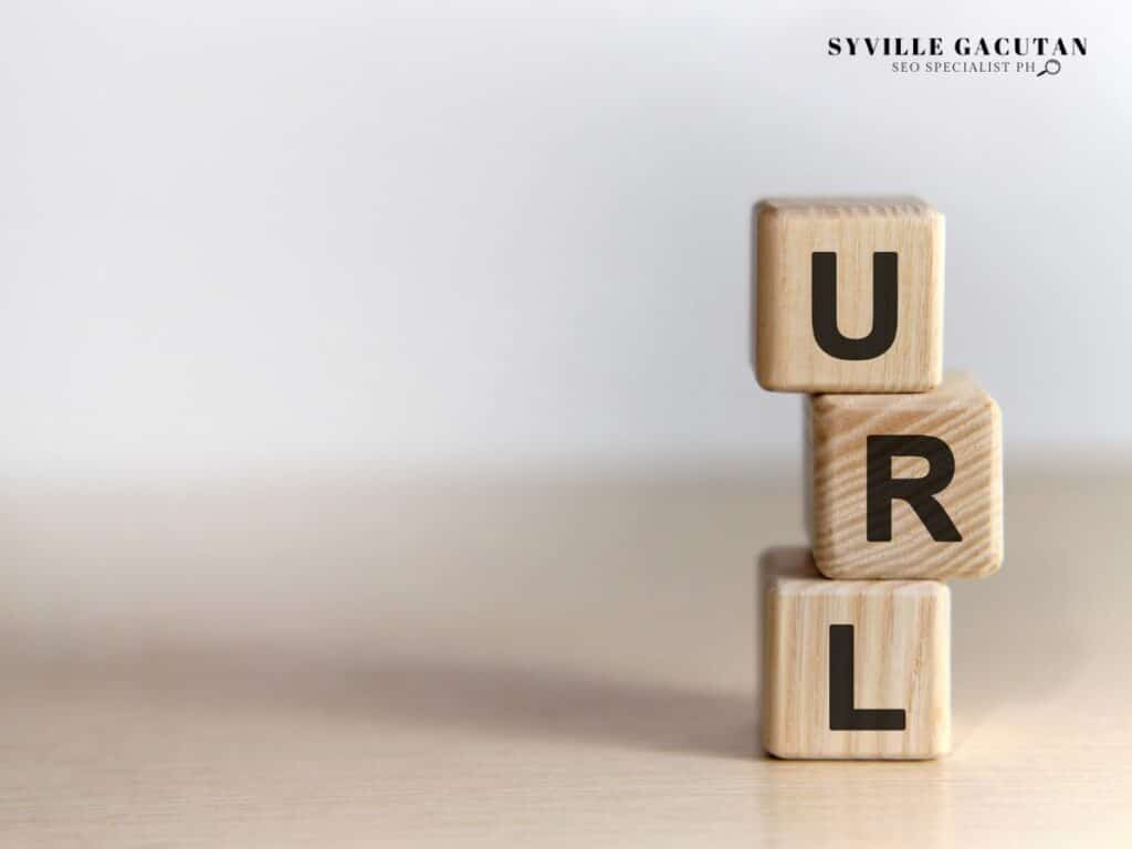 Wooden blocks stacked vertically spelling "URL" against light background.