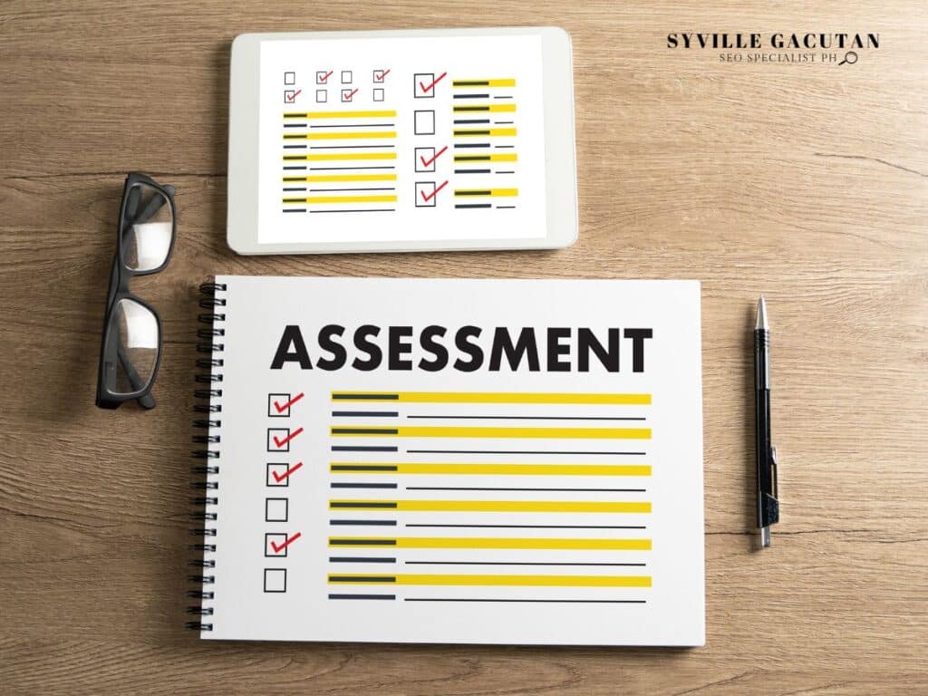 Assessment checklist notebook with tablet showing checkmarks and glasses on wooden desk.