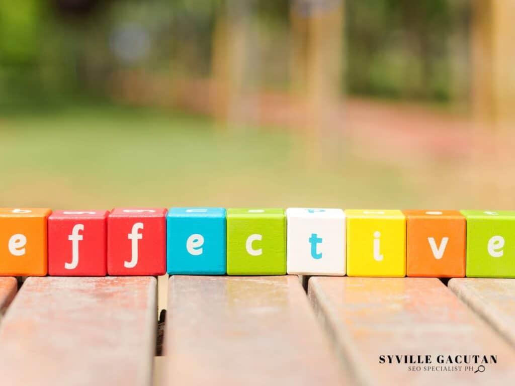 Colorful alphabet blocks spelling "effective" arranged in a row on wooden surface.