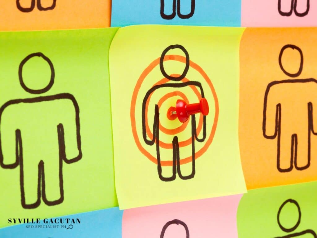 Targeted stick figure with a red pin on colourful sticky notes.