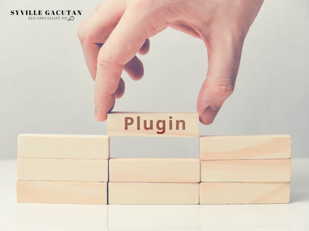 Hand placing wooden block labeled "Plugin" on stacked blocks against light background.