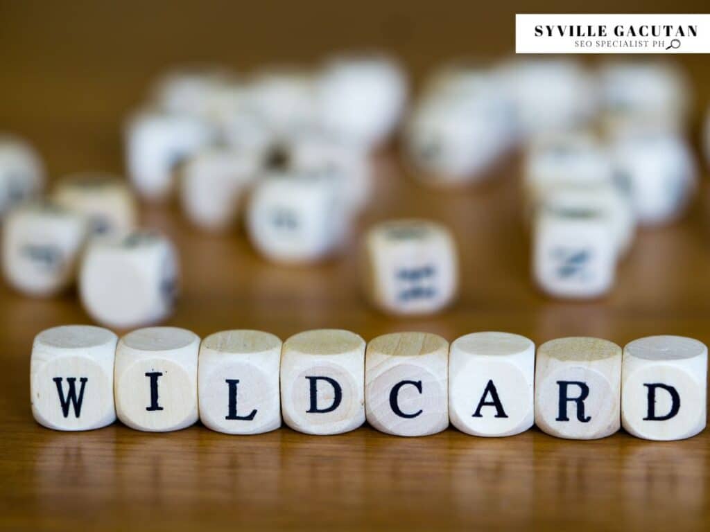 White letter dice spelling "WILDCARD" arranged in a row with blurred dice in background.