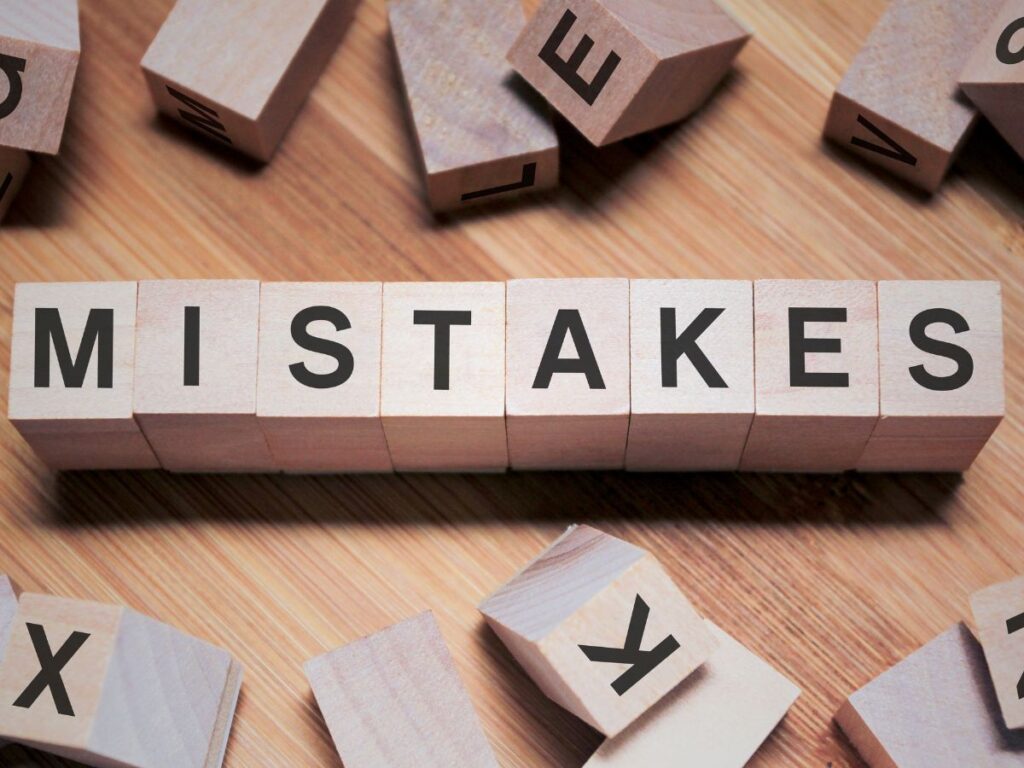 Wooden blocks spelling “MISTAKES”