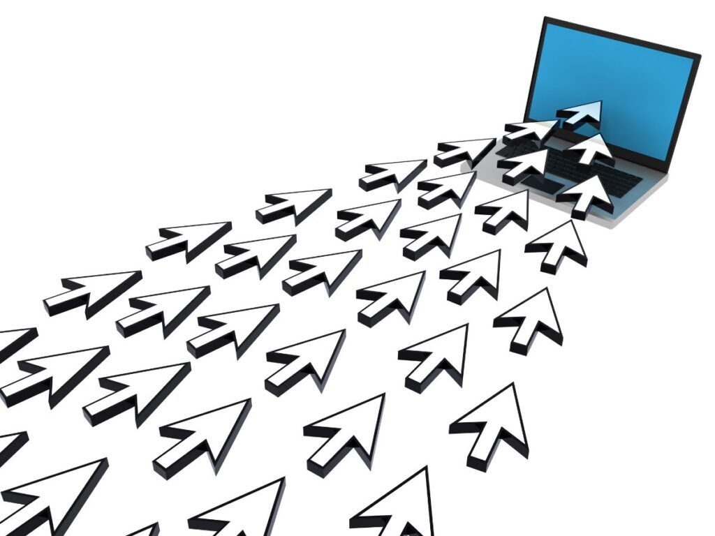Multiple cursor arrows flowing into a laptop, representing web traffic.
