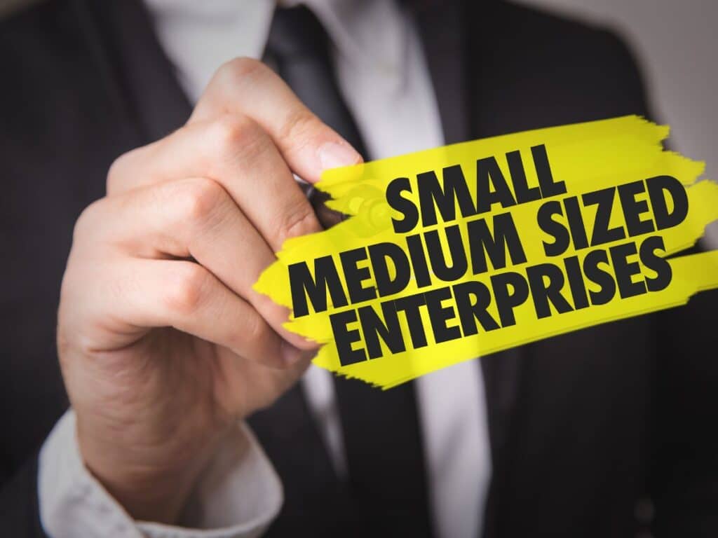 Hand pointing at “Small Medium Sized Enterprises” text on yellow banner.