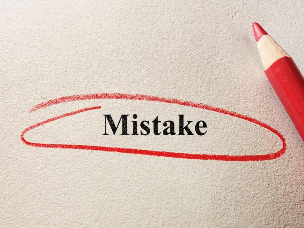 The word “Mistake” circled in red pencil on paper.