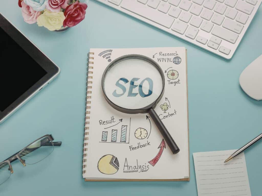 Magnifying glass over an SEO notes page with charts and keywords.