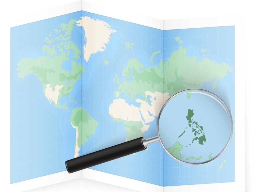 World map with magnifier highlighting the Philippines.