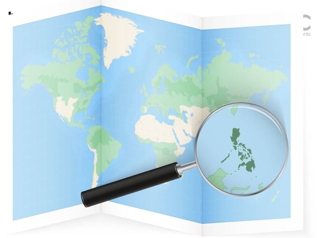 World map with magnifier highlighting the Philippines.