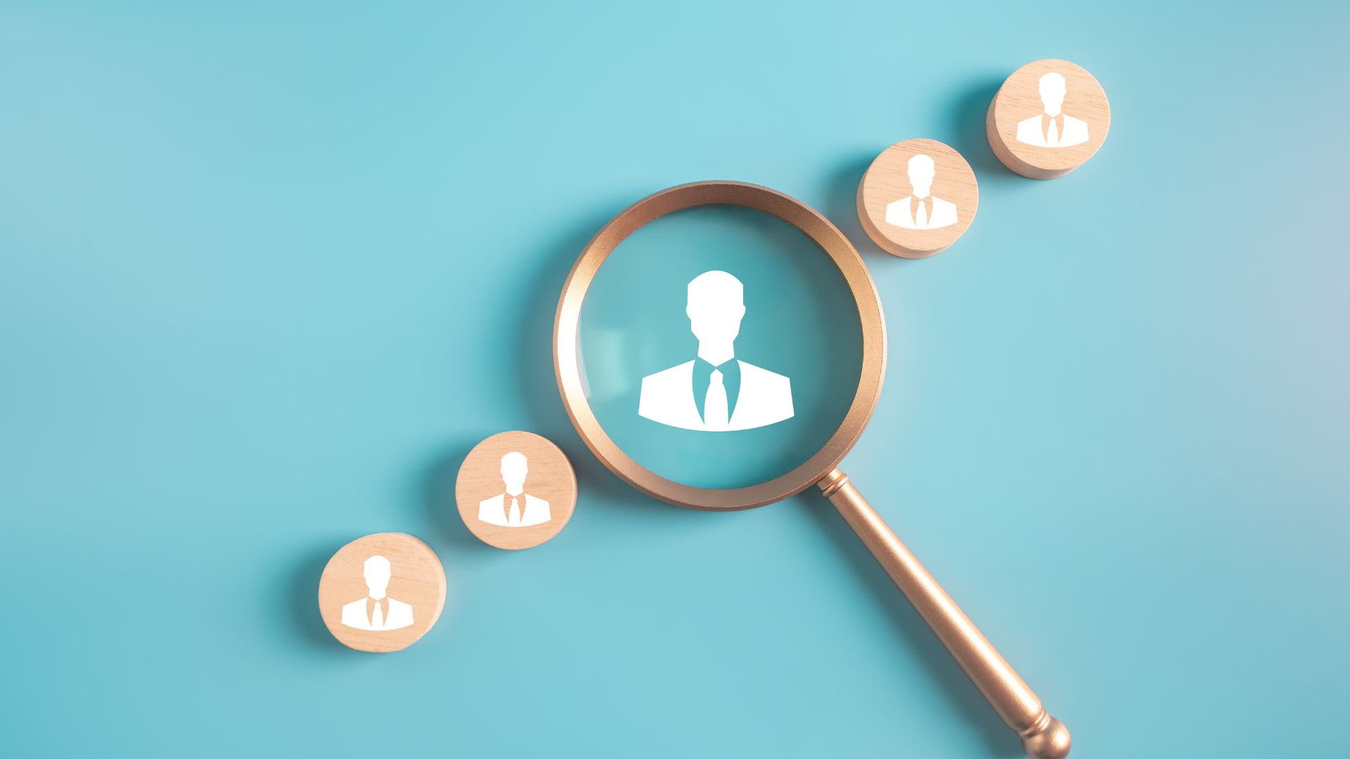 Magnifying glass highlighting a profile icon among smaller user icons.