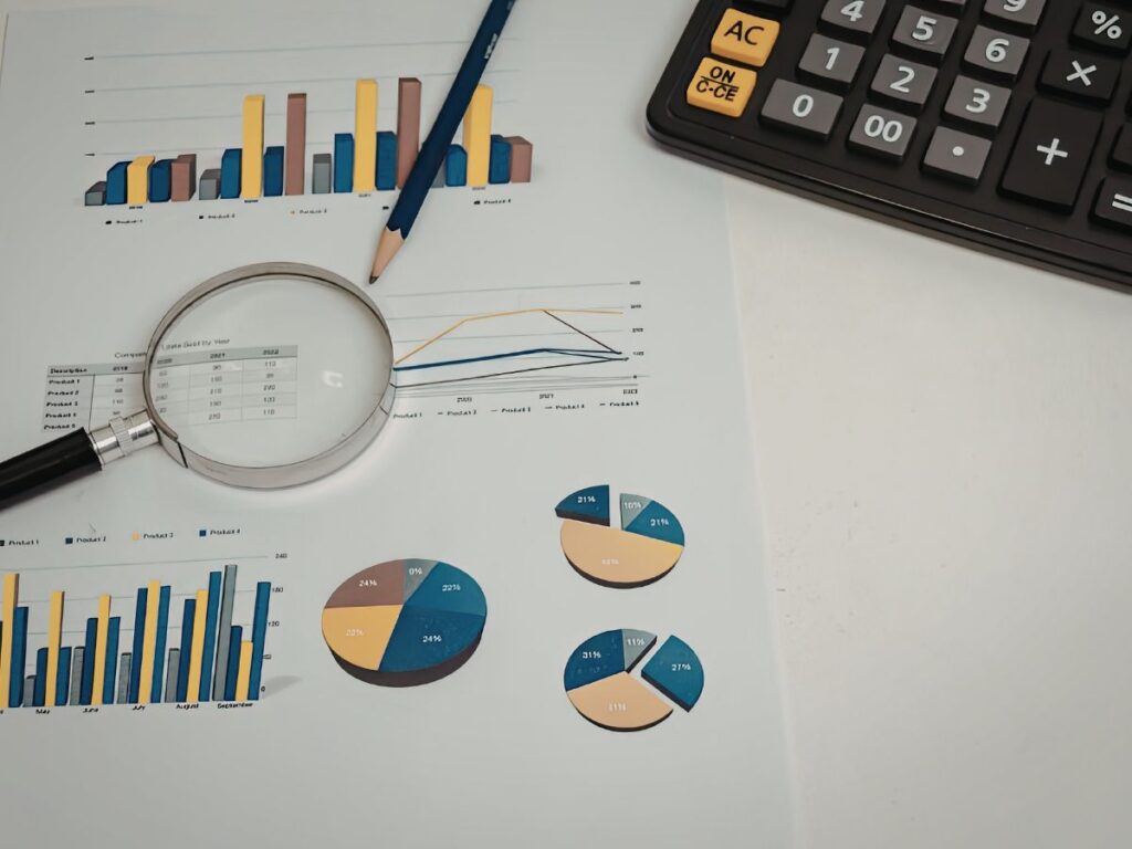 Charts with magnifying glass and calculator.