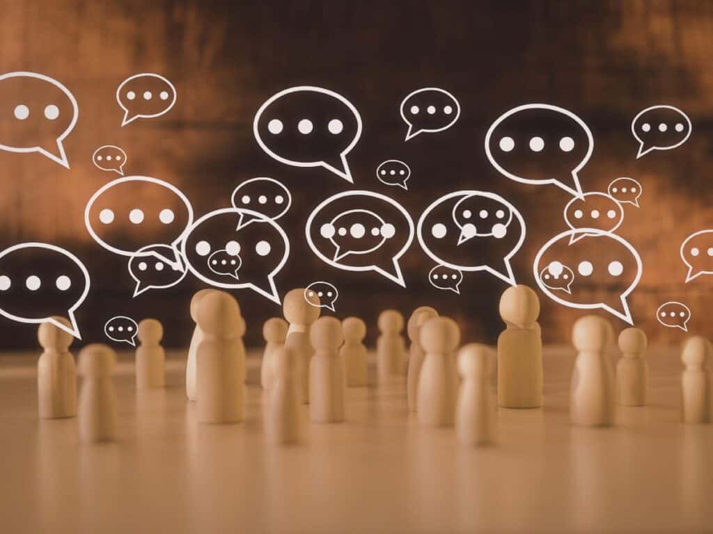 Wooden figures with speech bubbles showing conversation and engagement.