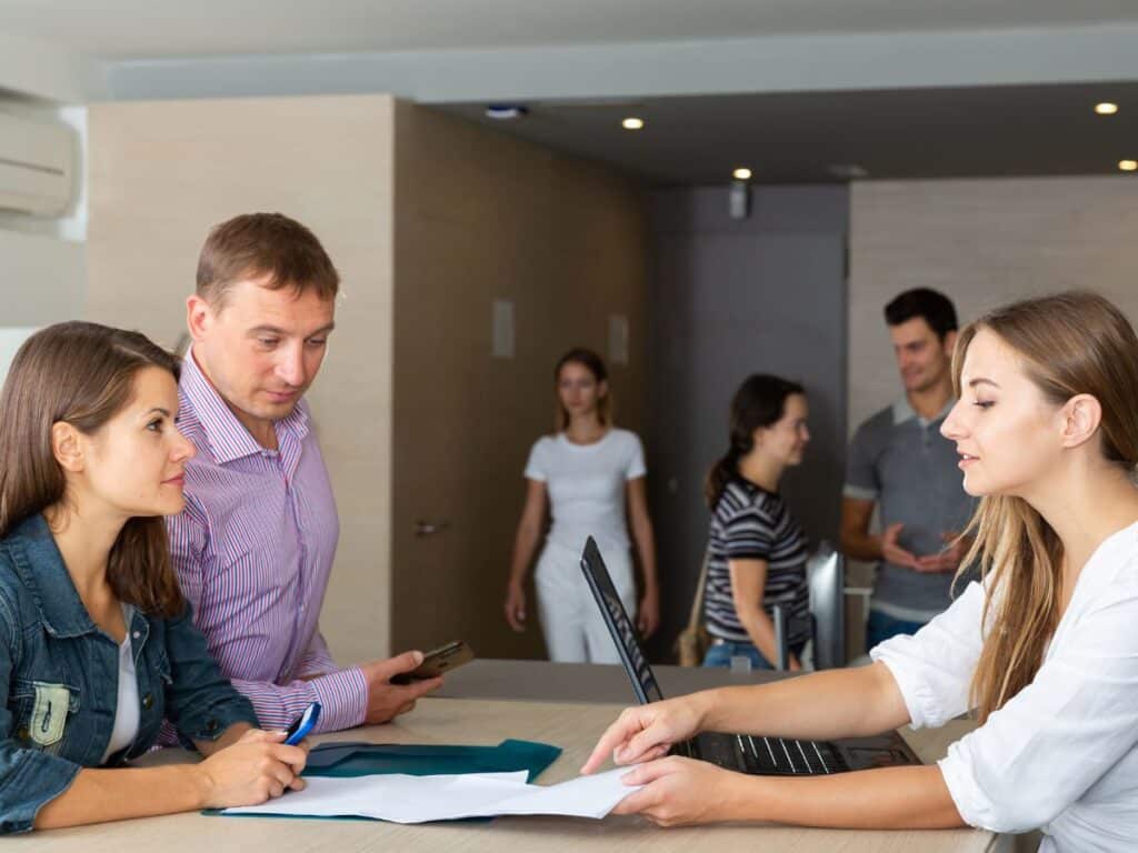 Clients discussing documents with staff at service desk.
