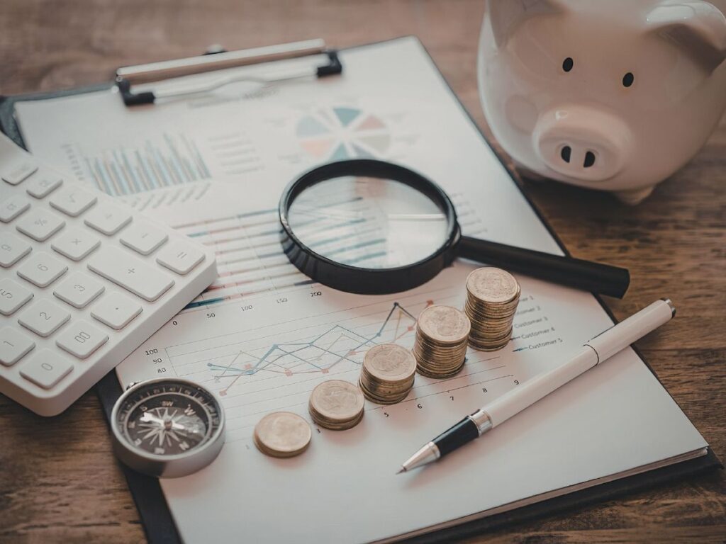 Financial charts with coins and magnifier.