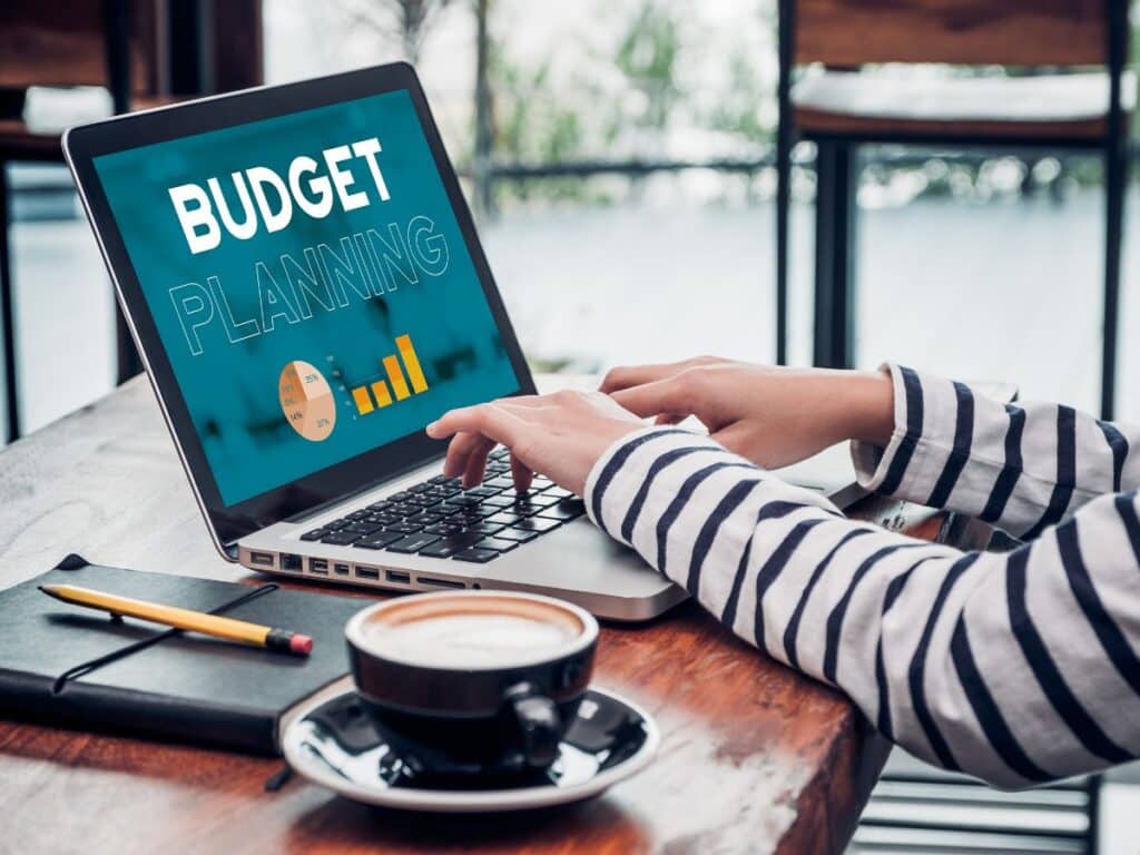 Person using laptop showing “Budget Planning” with charts.