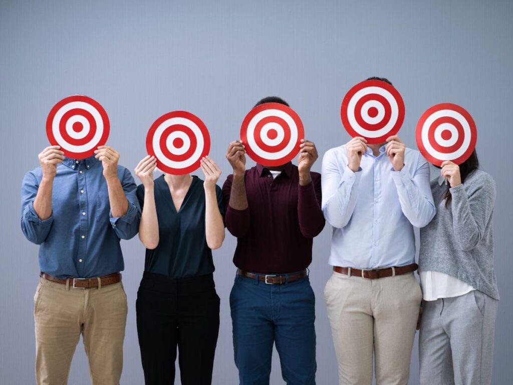 People holding target signs over their faces.