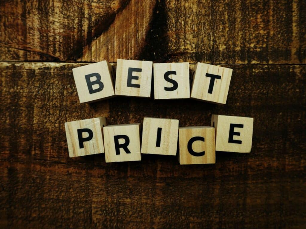 Wooden blocks spelling “Best Price” on rustic surface.