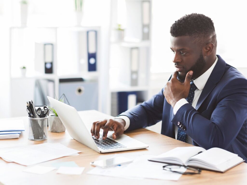 Businessman working thoughtfully on a laptop.