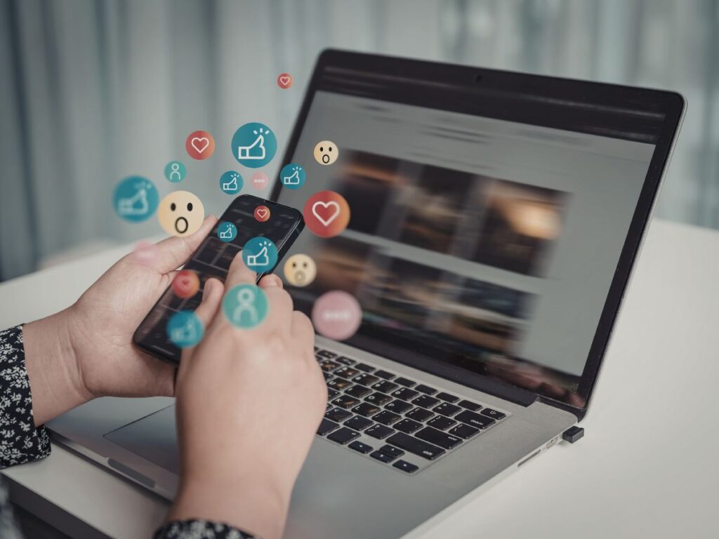 Person using social media on phone and laptop.