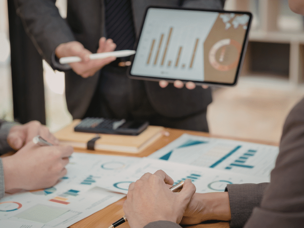 Business meeting with tablet showing charts and data analysis.