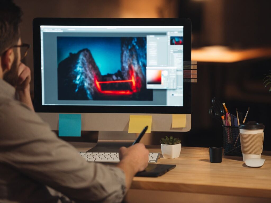 Designer editing an image on a desktop screen.