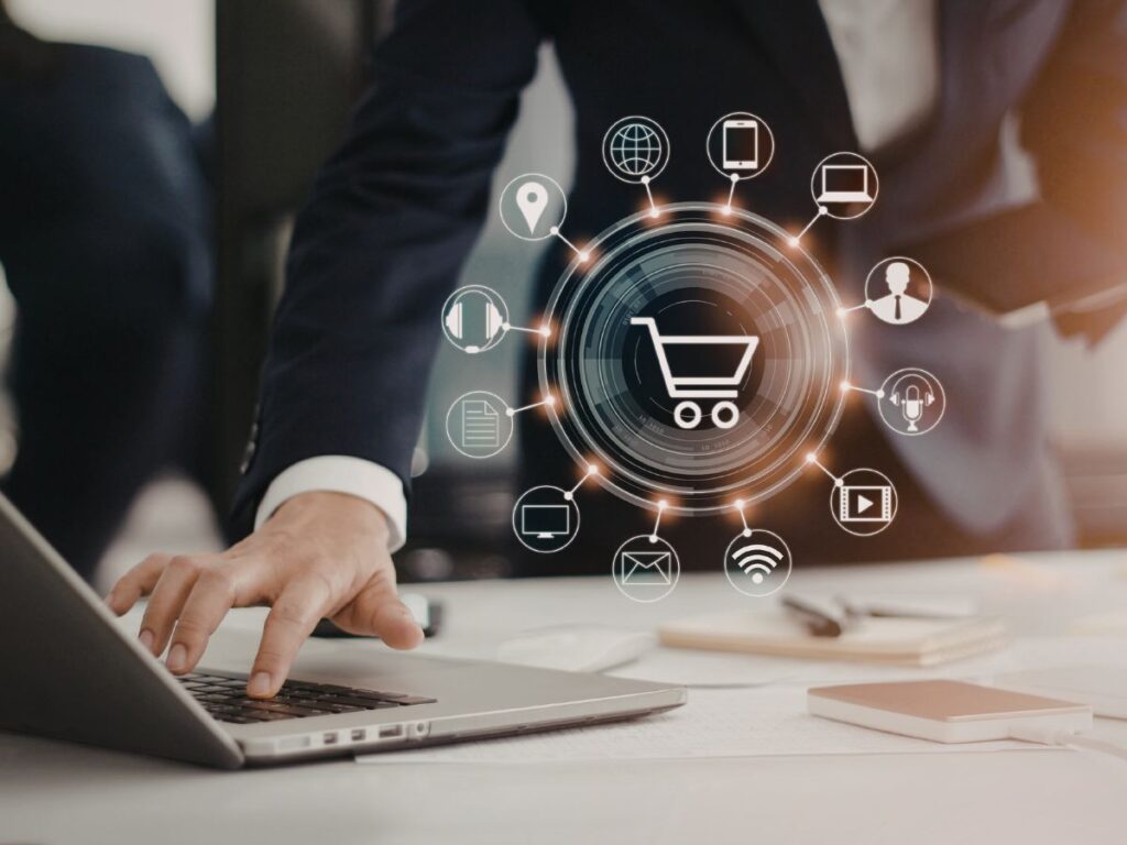 Person using laptop with e-commerce icons overlay.
