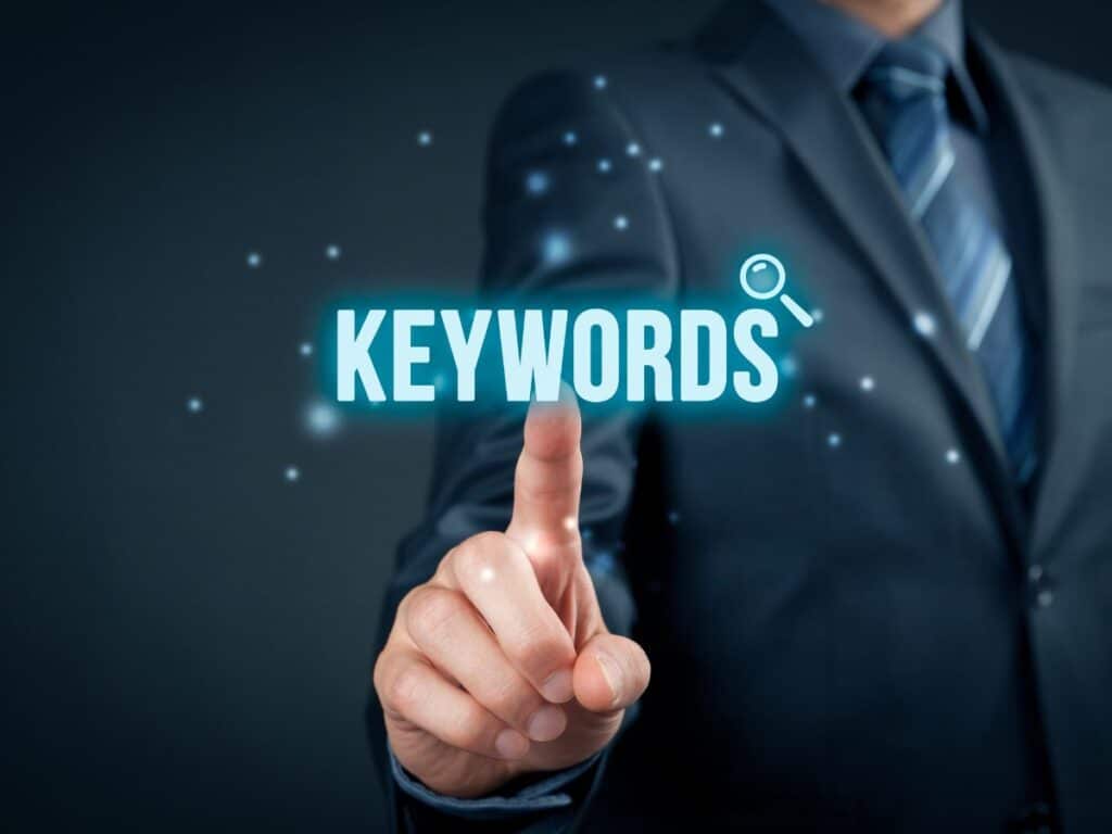 Businessman pressing a glowing “KEYWORDS” button on a digital screen.