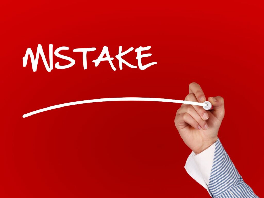 Hand writing “Mistake” on a red background.
