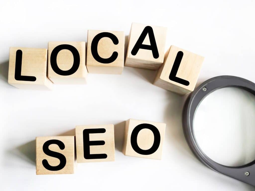Wooden blocks spelling “LOCAL SEO” beside a magnifying glass.