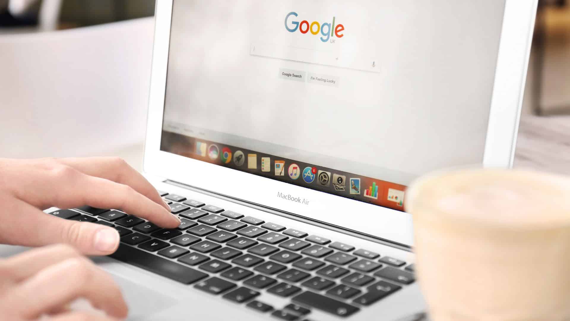 Person using a laptop with Google search open on the screen.
