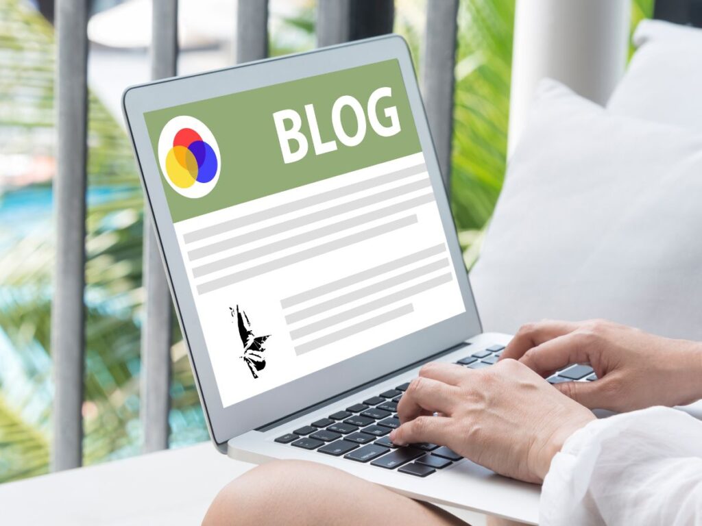 Person typing on a laptop displaying a blog page.