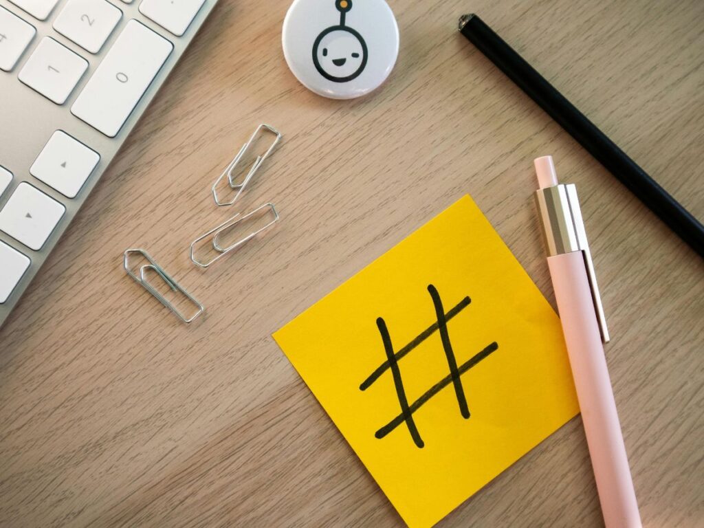 Hashtag note on a desk with pens and clips